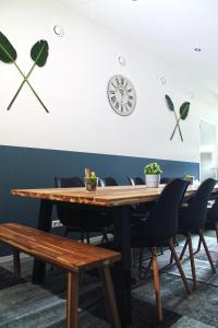 a dining room table with chairs and a clock on the wall at B&B Manege Groenewoude in Woudenberg