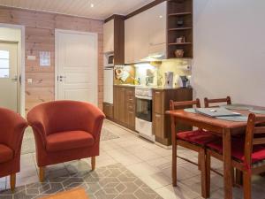 a kitchen with a wooden table and chairs and a table and chairsktop at Holiday Home Karitahko a 7 by Interhome in Tahkovuori