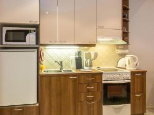 a kitchen with wooden cabinets and a sink and a refrigerator at Holiday Home Karitahko a 7 by Interhome in Tahkovuori