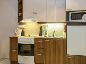 a kitchen with white appliances and wooden cabinets at Holiday Home Karitahko a 6 by Interhome in Tahkovuori