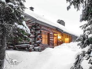 a log cabin in the snow with a pile of snow at Holiday Home Kiiruna by Interhome in Sirkka