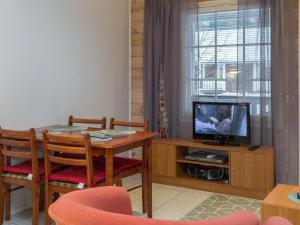 a living room with a table and a television at Holiday Home Karitahko a 7 by Interhome in Tahkovuori