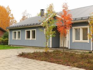 una casa azul con un árbol delante en Holiday Home Villa lehmus by Interhome en Rovaniemi