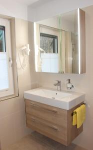 un bagno con lavandino e specchio di Haus Bruschek a Sankt Gilgen