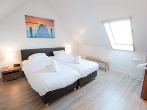 a bedroom with a bed with white sheets and a window at Holiday Home Oesterdam Resort-1 by Interhome in Tholen