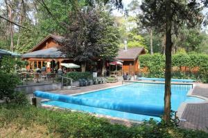 a swimming pool in front of a house at Chalet M24 Bambi in Doornspijk
