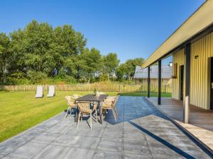 a patio with a table and chairs in a yard at Holiday Home Oesterdam Resort-1 by Interhome in Tholen