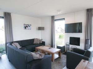 a living room with a couch and a table at Holiday Home Oesterdam Resort-1 by Interhome in Tholen +20 photos