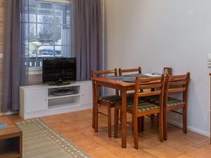 comedor con mesa, sillas y TV en Holiday Home Karitahko a 2 by Interhome en Tahkovuori