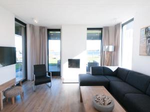 a living room with a couch and a table at Holiday Home Oesterdam Resort-1 by Interhome in Tholen