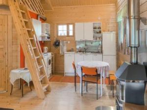 eine Küche mit einem Tisch und einer Leiter in einem Zimmer in der Unterkunft Holiday Home Uisku by Interhome in Punkalaidun