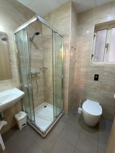uma casa de banho com um chuveiro, um WC e um lavatório. em Grand Harbour Hotel em Valletta