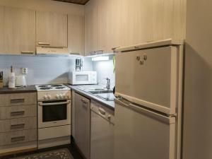 a kitchen with a white refrigerator and a stove at Holiday Home Vuokatinportti a 11 by Interhome in Lahdenperä