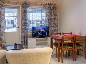a living room with a table and a tv at Holiday Home Karitahko a 6 by Interhome in Tahkovuori