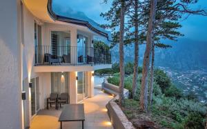 a house with a balcony with a table and chairs at Villa Abetaia With Pool in Tremosine Sul Garda