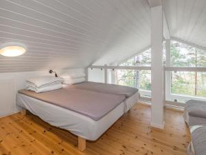 uma cama num quarto branco com uma grande janela em Holiday Home Sjöboda sea by Interhome em Inkoo