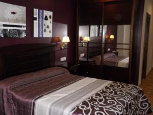 a bedroom with a bed and a large mirror at Alcaidia De Magina in Cambil