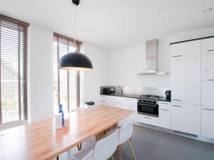 een keuken met een houten tafel en witte kasten bij Holiday Home Oesterdam Resort-1 in Tholen
