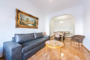 ein Wohnzimmer mit einem Sofa und einem Tisch in der Unterkunft Victoria Supreme Suite in Athen