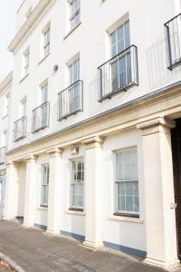 ein weißes Gebäude mit Balkon auf einer Straße in der Unterkunft Spa Court in Cheltenham