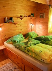 a bed in a room with a wooden wall at MaRei-Hütte in Hohentauern