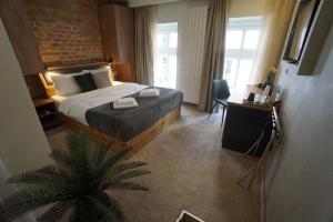 a hotel room with a bed and a palm tree at Urban Lodge Belgrade in Belgrade