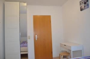 a bedroom with a wooden door and a desk at Aquamarin in Dahme