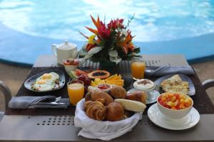 a tray of breakfast food on a table by a pool at Le Wafou in Abidjan