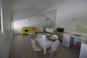 - une cuisine avec une table et des chaises dans la chambre dans l'établissement BALAGA ocarina, à Sainte-Anne