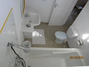 a white bathroom with a toilet and a sink at BALAGA ocarina in Sainte-Anne +1 photo