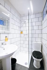 La salle de bains est pourvue de toilettes, d'un lavabo et d'une douche. dans l'établissement The Warwick By Aura Collection, à Londres