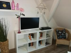 TV su supporto bianco in camera di Ferienwohnung Bender a Gemünden