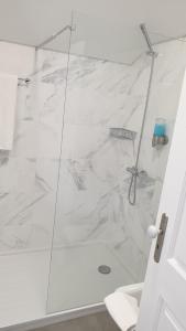 a bathroom with a shower with white marble at Edificio Charles 303 in Funchal +18 photos