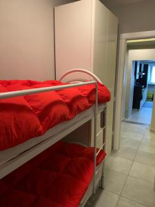 a room with two bunk beds with red sheets at Appartamento Ateleta via Colle Sisto in Ateleta