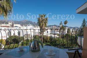 a table with coffee cups on a balcony with a view at Acapulco playa Nerja 407 planta superior in Nerja