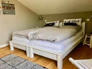a bed with white sheets and pillows on it at Fewo Seesucht-Hohwacht in Hohwacht
