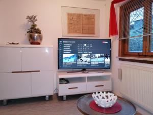 uma sala de estar com uma televisão e uma mesa em Ferienwohnung Müller em Steinach