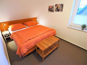 ein Schlafzimmer mit einem Bett mit orangefarbener Bettwäsche und einem Fenster in der Unterkunft Blauort12 in Büsum