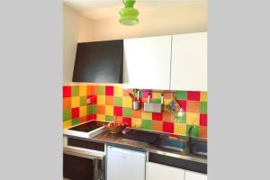een keuken met kleurrijke tegels op de muur bij Les Lavandières in Vernet-les-Bains