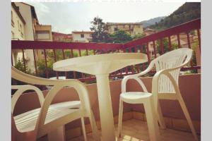 een witte tafel en 2 stoelen op een balkon bij Les Lavandières in Vernet-les-Bains