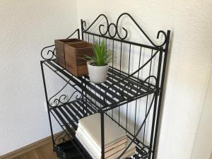 a black iron shelf with books and a plant on it at Ferienwohnung Maria in Überlingen
