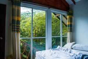 a bedroom with a large window with a bed in front at Sarada Beach Resort Yala in Tissamaharama