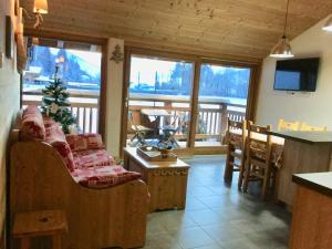 a living room with a christmas tree on a balcony at Le Chalet Du Pic SPA privé & Fitness in Taninges