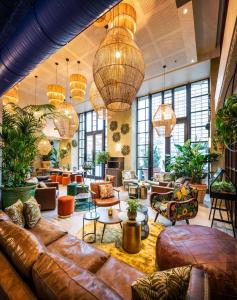 vestíbulo con sofá de cuero, mesas y sillas en Hotel Indigo Brussels - City, an IHG Hotel en Bruselas