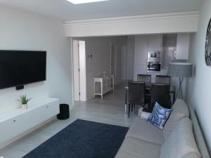 a living room with a couch and a flat screen tv at Cozy Luxury in San Bartolomé