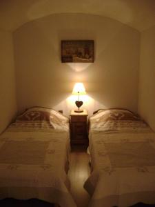 a bedroom with two beds and a lamp in it at fleur de neige in Gilly-sur-Isère