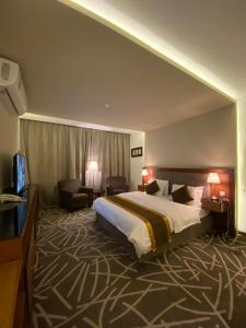 Pokój hotelowy z dużym łóżkiem i kanapą w obiekcie Desert Rose w mieście Ha'il