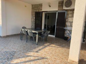 une table et des chaises dans un patio avec un bâtiment dans l'établissement Apartmani Antonio 1, à Brodarica