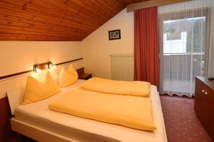1 dormitorio con 2 camas y ventana en Appartements Sigmair, en Valdaora
