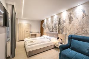 a bedroom with a bed and a blue chair at Casa SEDRA in Braşov